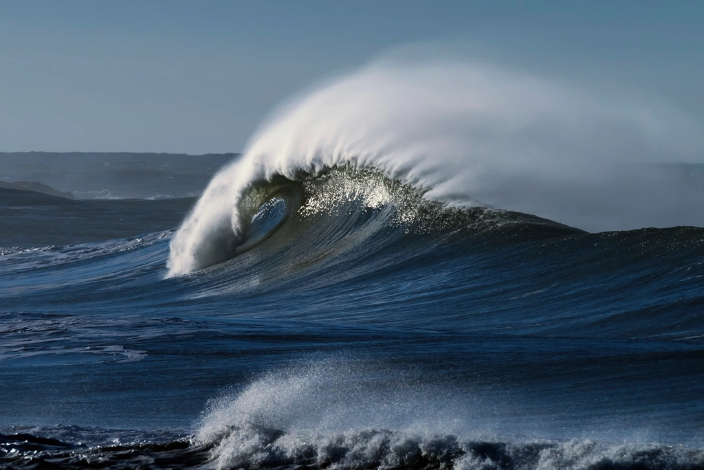 Ocean waves crashing shoreline, blue