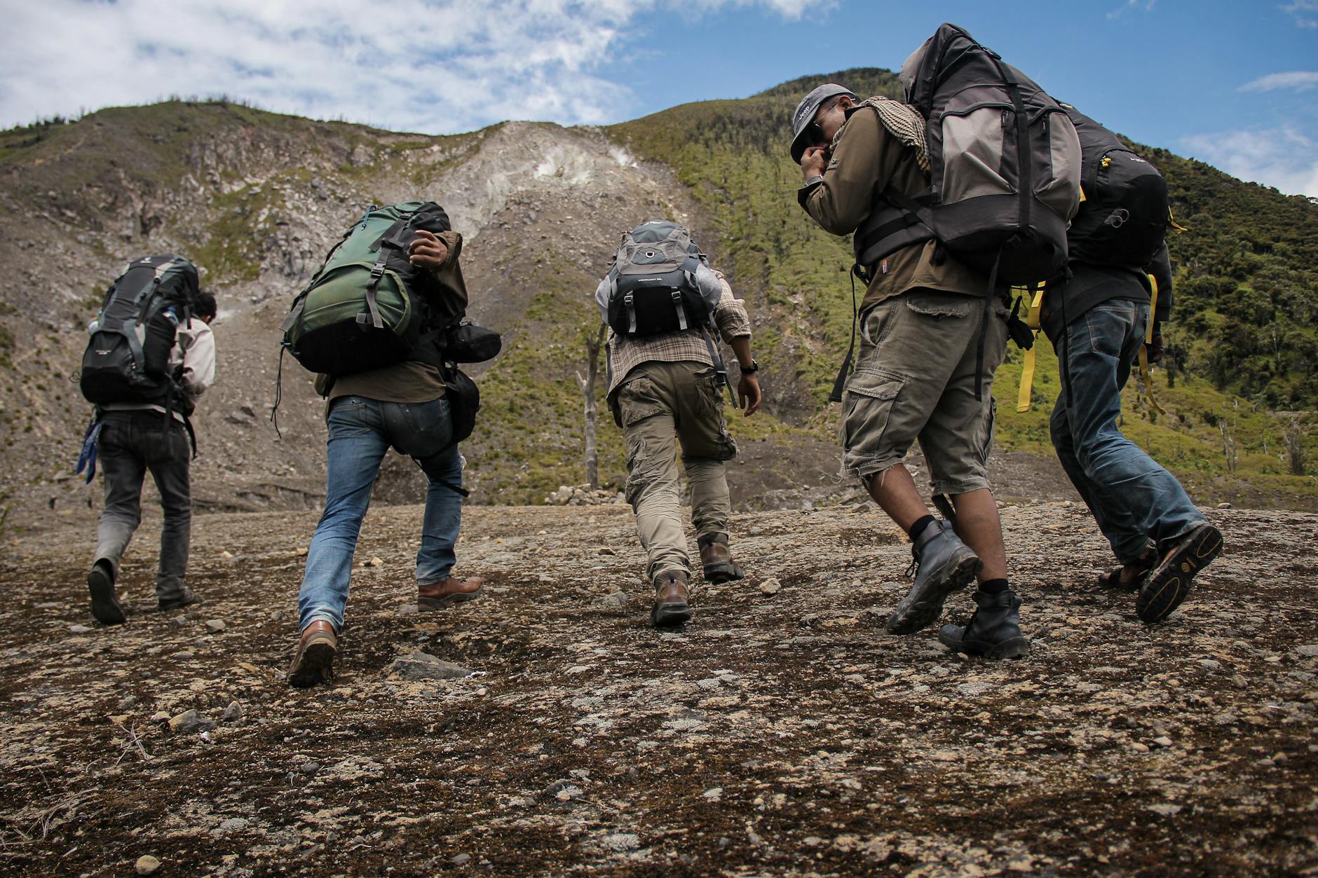 five men running near mountain