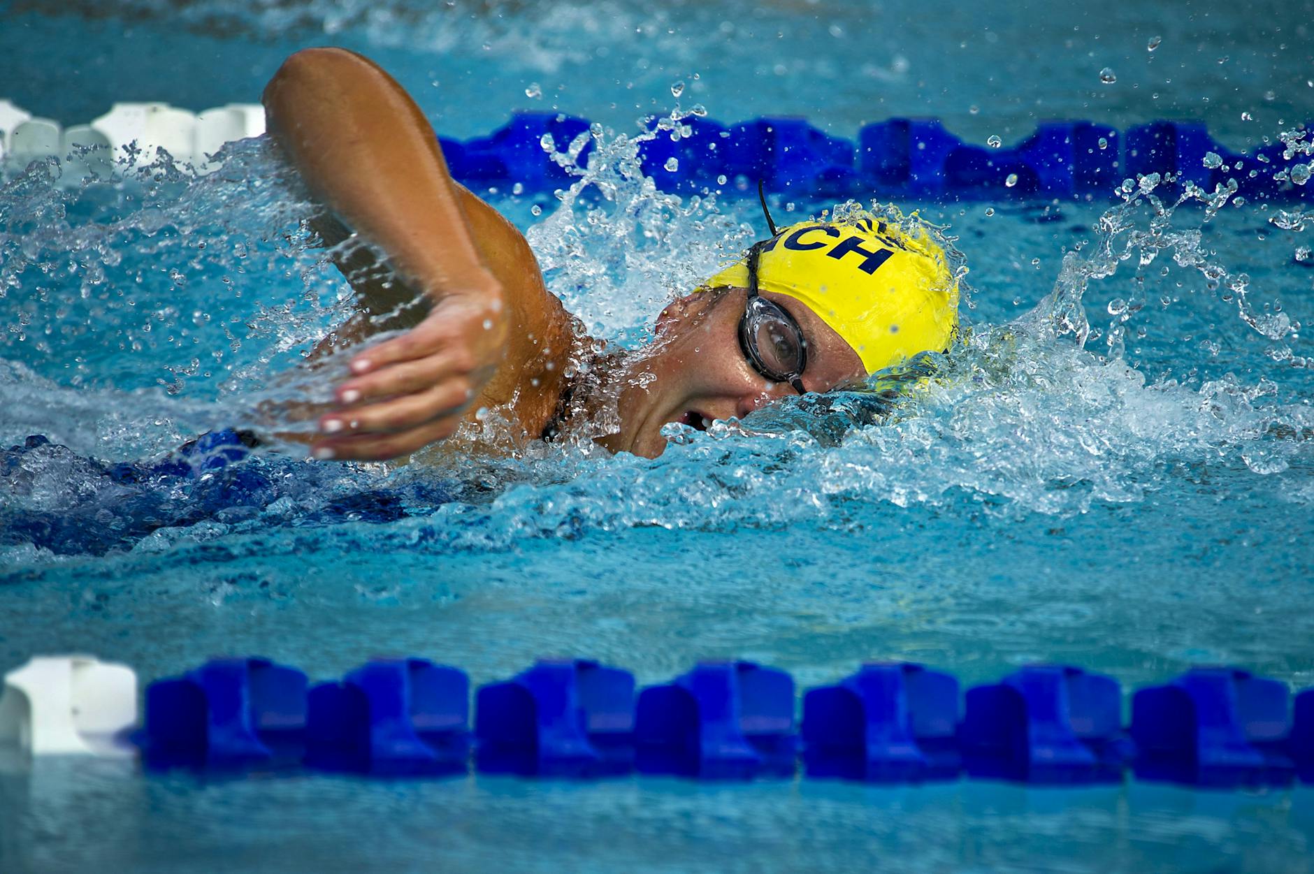 person wearing yellow swimming cap on swimming pool